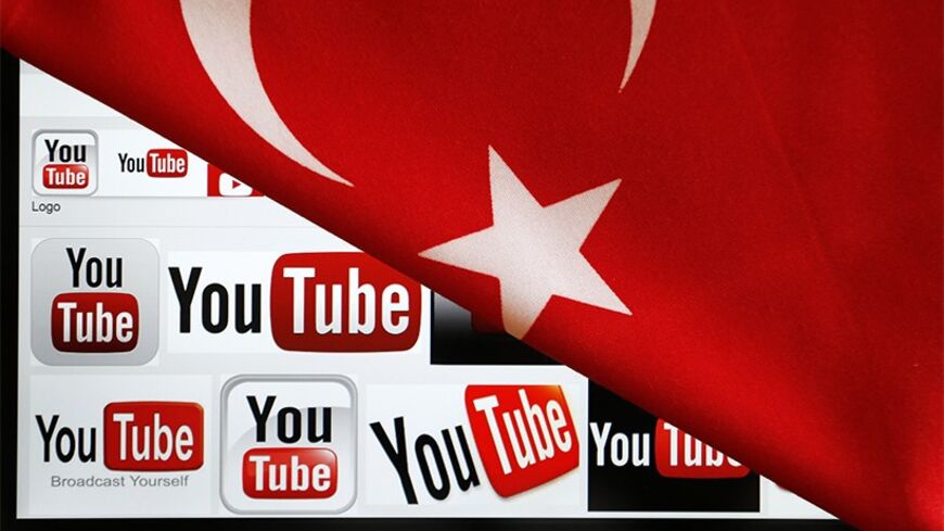 YouTube logos displayed on a laptop screen partially covered with Turkey's national flag in this photo illustration taken in Ankara March 27, 2014.  Turkish Prime Minister Tayyip Erdogan described the leaking on YouTube on Thursday of a recording of top security officials discussing possible military operations in Syria as "villainous" and the government blocked access to the video-sharing site. REUTERS/Umit Bektas (TURKEY - Tags: CIVIL UNREST POLITICS PORTRAIT SCIENCE TECHNOLOGY) - RTR3IVDE