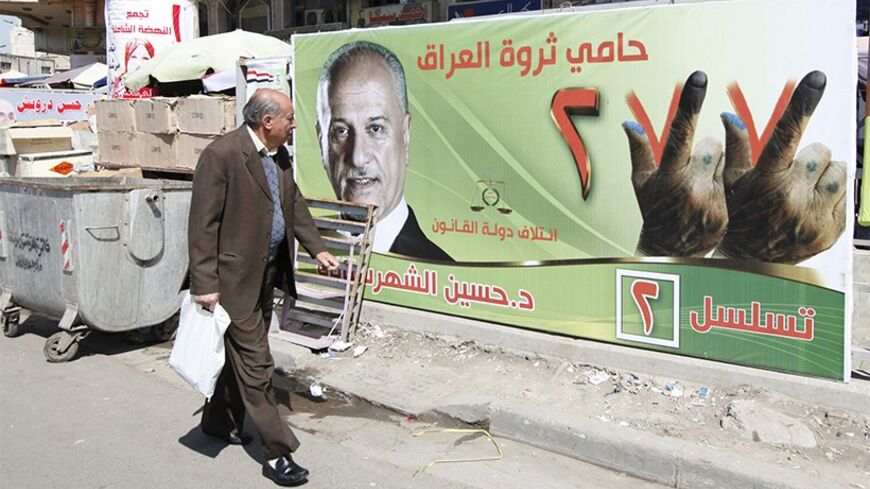 A man looks at an election campaign poster of Iraq's Deputy Prime Minister Hussain al-Shahristani in Baghdad April 3, 2014. Iraq's parliamentary election is scheduled for April 30. REUTERS/Ahmed Saad (IRAQ - Tags: POLITICS ELECTIONS) - RTR3JUTM