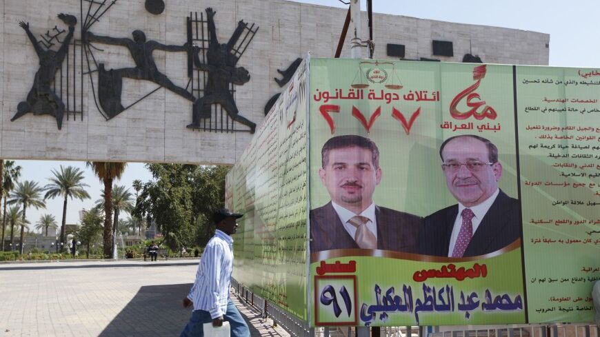 A man walks past an election campaign poster of Mohammed Abed Al-Kazem Aqeeli (C) of Iraq's Prime Minister Nuri al-Maliki's State of Law coalition in Baghdad April 3, 2014. Iraq's parliamentary election is scheduled for later this month. REUTERS/Ahmed Saad (IRAQ - Tags: POLITICS ELECTIONS) - RTR3JUU1