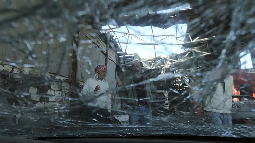 Palestinians are seen through a car window which Hamas police said was damaged in an Israeli strike on a workshop in the northern Gaza Strip April 4, 2014. REUTERS/Mohammed Salem (GAZA - Tags: POLITICS CIVIL UNREST TPX IMAGES OF THE DAY) - RTR3JW08