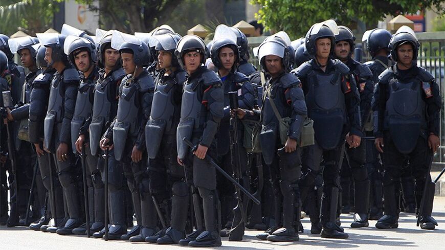 Police officers take positions outside Cairo University during a protest inside by supporters of the Muslim Brotherhood and ousted Egyptian President Mohamed Mursi, in Cairo April 14, 2014.  REUTERS/Mohamed Abd El Ghany (EGYPT - Tags: POLITICS CIVIL UNREST EDUCATION) - RTR3L8EV