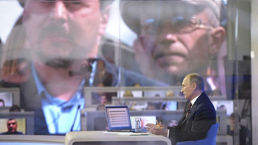 Russian President Vladimir Putin takes part in a live broadcast nationwide phone-in in Moscow April 17, 2014. Putin said Russian forces had been active in Crimea in order to support local defense forces, the first time he has admitted deployment of Russian troops on the Black Sea peninsula. REUTERS/Alexei Druzhinin/RIA Novosti/Kremlin (RUSSIA - Tags: POLITICS) ATTENTION EDITORS - THIS IMAGE HAS BEEN SUPPLIED BY A THIRD PARTY. IT IS DISTRIBUTED, EXACTLY AS RECEIVED BY REUTERS, AS A SERVICE TO CLIENTS - RTR3L