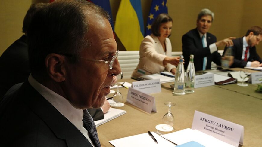 Russia's Foreign Minister Sergei Lavrov (L) looks on as U.S. Secretary of State John Kerry (2nd R) starts a quadrilateral meeting in Geneva, between representatives of the U.S., Ukraine, Russia and the European Union about the ongoing situation in Ukraine April 17, 2014.    REUTERS/Jim Bourg  (SWITZERLAND - Tags: POLITICS) - RTR3LN59
