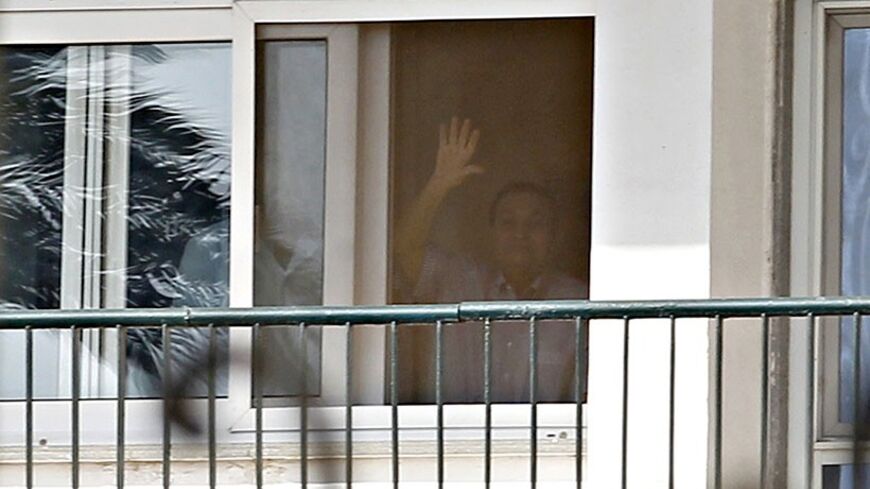 Former Egyptian president Hosni Mubarak waves from his room during a celebration by his supporters of the 32nd anniversary of the liberation of Sinai in front of Maadi military hospital on the outskirts of Cairo April 25, 2014. Mubarak under house arrest in the hospital faces retrial for charges of complicity in the killings of protesters during the 2011 Egyptian uprising. REUTERS/Amr Abdallah Dalsh  (EGYPT - Tags: ANNIVERSARY POLITICS CIVIL UNREST TPX IMAGES OF THE DAY) - RTR3MNVK