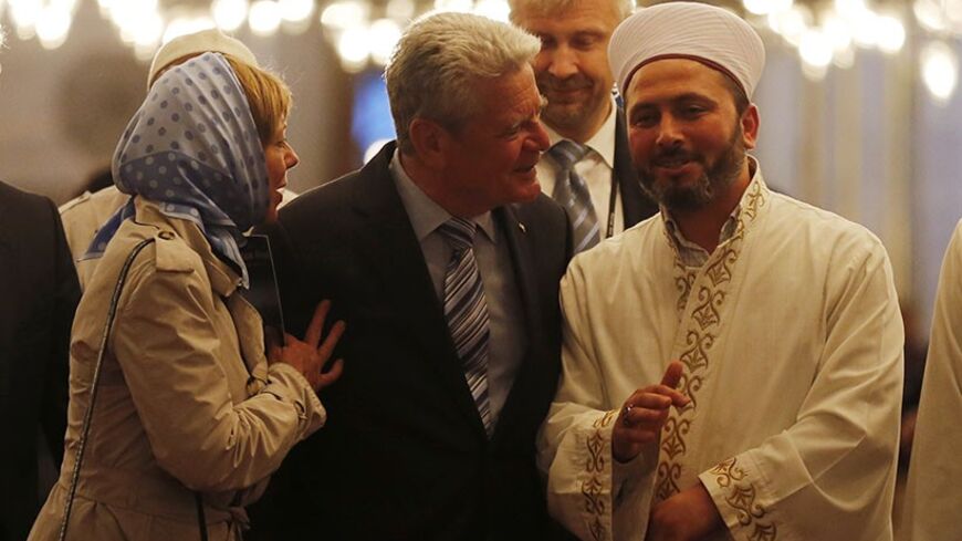 Germany's President Joachim Gauck (C) and his partner Daniela Schadt (L) listen to an Imam as they visit the Ottoman-era Sultanahmet mosque, known as Blue mosque, in Istanbul April 29, 2014. REUTERS/Murad Sezer (TURKEY  - Tags: POLITICS RELIGION) - RTR3N4QT