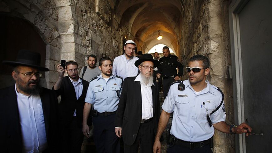 Israeli police escort Rabbi Yisrael Ariel (C) from the compound known to Muslims as Noble Sanctuary and to Jews as Temple Mount in Jerusalem's Old City October 10, 2013. An Israeli police spokesman said on Thursday three Jewish visitors, including Ariel, were detained after they failed to obey police guidelines at the compound. REUTERS/Baz Ratner (JERUSALEM - Tags: POLITICS RELIGION) - RTX145XT