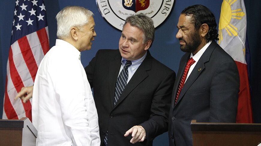 Philippine Foreign Affairs Secretary Albert Del Rosario (L) chats with U.S. Representatives Chris Smith and Al Green (R) after their news conference at the Department of Foreign Affairs headquarters in Pasay city, metro Manila November 25, 2013. Smith along with the members of the U.S. congressional delegation said in a news conference on Monday, that they expressed their strong support for Philippine humanitarian relief operations as well as upcoming reconstruction and rehabilitation plans of the governmen