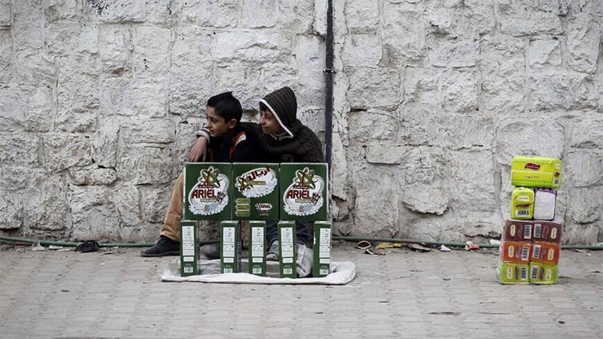 Children sell washing detergent on a sidewalk in Aleppo December 1, 2013. REUTERS/Molhem Barakat (SYRIA - Tags: CIVIL UNREST SOCIETY POLITICS CONFLICT) - RTX16005