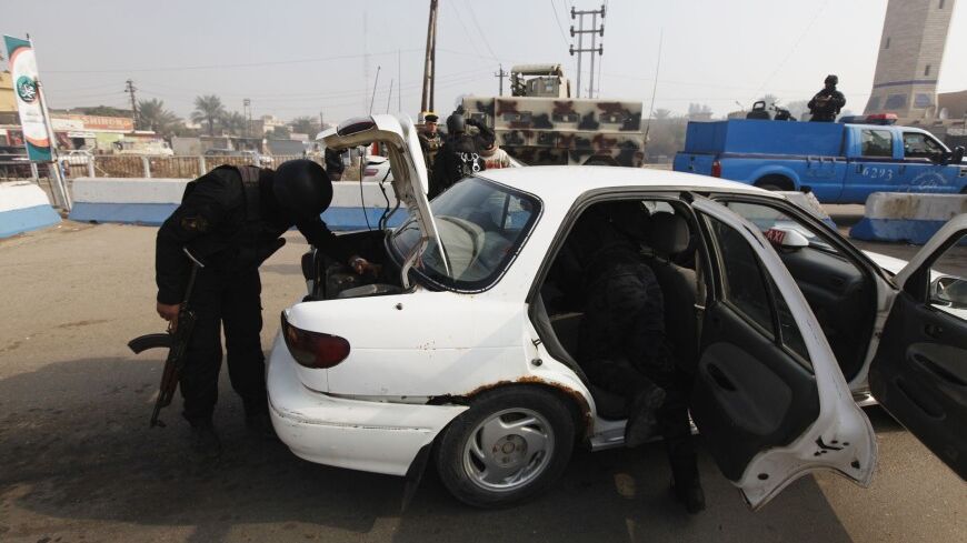 Police officers search a vehicle at a checkpoint,  as security increases after a bomb attack, at Abu Ghraib district, west of Baghdad, January 9, 2014. A suicide bomber killed 13 Iraqi army recruits and wounded more than 30 in Baghdad on Thursday, police said, in an attack on men responding to a government appeal for volunteers to help fight al Qaeda-linked militants in Anbar province.  REUTERS/Ahmed Saad (IRAQ - Tags: CIVIL UNREST POLITICS MILITARY) - RTX177MB