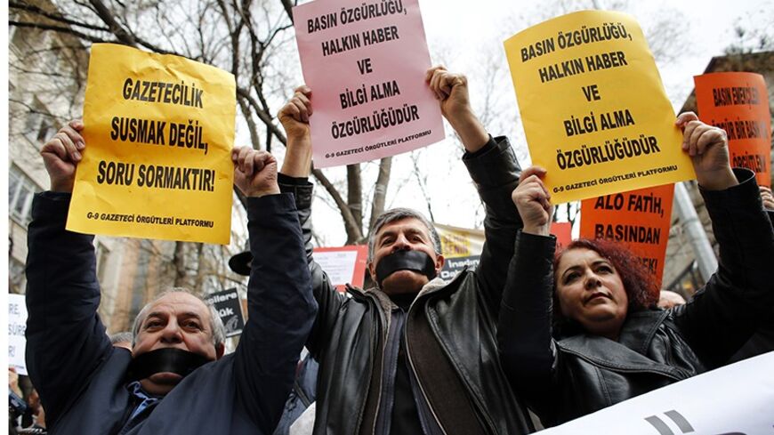 Journalists demanding freedom for the media take part in a protest against Turkey's ruling AK Party (AKP) in Ankara February 15, 2014. The signs read: "Journalism is asking questions, not keeping silent" (L) and "Press freedom also means people's freedom to access information" (C and R). REUTERS/Umit Bektas (TURKEY - Tags: POLITICS CIVIL UNREST MEDIA) - RTX18VGG