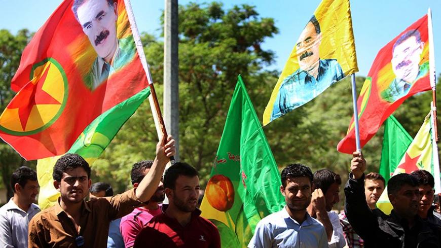Iraqi Kurdish supporters of the Kurdistan Workers Party (PKK) hold flags bearing portraits of jailed PKK leader Abdullah Ocalan during a demonstration in Arbil on April 12, 2014 against the decision by Kurdish authorities to dig a trench along the border with neighboring Syria. The Kurdish autonomous region has backed Kurds in Syria against the extremists and has taken in some 200,000 refugees from the bloody conflict. AFP PHOTO / SAFIN HAMED        (Photo credit should read SAFIN HAMED/AFP/Getty Images)