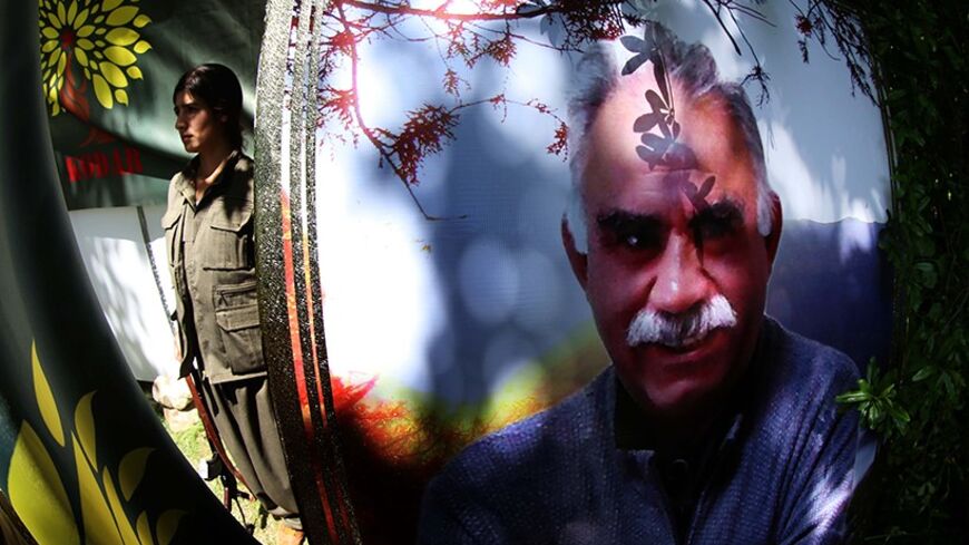 A female member of the anti-Iranian group, the Party of Free Life of Kurdistan (PJAK), stands near a poster of jailed  Kurdistan Workers' Party (PKK) leader, Abdullah Ocalan, in the grounds of their base deep in the Qandil mountains of northern Iraq's Kurdish autonomous region, on May 5, 2014. The PJAK, is a Kurdish political and militant organisation which has waged an intermittent armed struggle since 2004 against the Iranian government to seek cultural and political rights and self-determination for Kurd