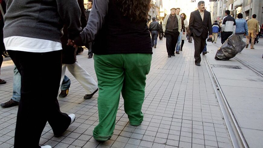 Istanbul, TURKEY:  An overweight couple walks on Istiklal avenue in Istanbul, 15 November 2006. Health ministers and other senior officials from 53 European countries opened talks in Istanbul to map out a strategy to combat obesity, seen as one of the greatest health challenges of the era. AFP PHOTO/MUSTAFA OZER  (Photo credit should read MUSTAFA OZER/AFP/Getty Images)
