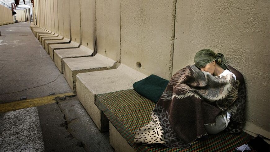 A homeless Palestinian woman sleeps at the Erez border crossing in Gaza January 23, 2009. REUTERS/Yannis Behrakis (GAZA) - RTR23S6X