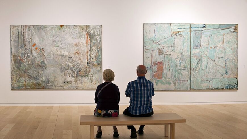Visitors sit in front of paintings by Israeli artist Joseph Zaritsky in a section of a new wing of the Tel Aviv Museum November 2, 2011, during its official opening. The additional wing named after it's American donors Herta and Paul Amir was designed by Architect Preston Scott Cohen who heads the Harvard University Graduate School of Architecture. REUTERS/ Nir Elias (ISRAEL - Tags: SOCIETY) - RTR2TJ1H
