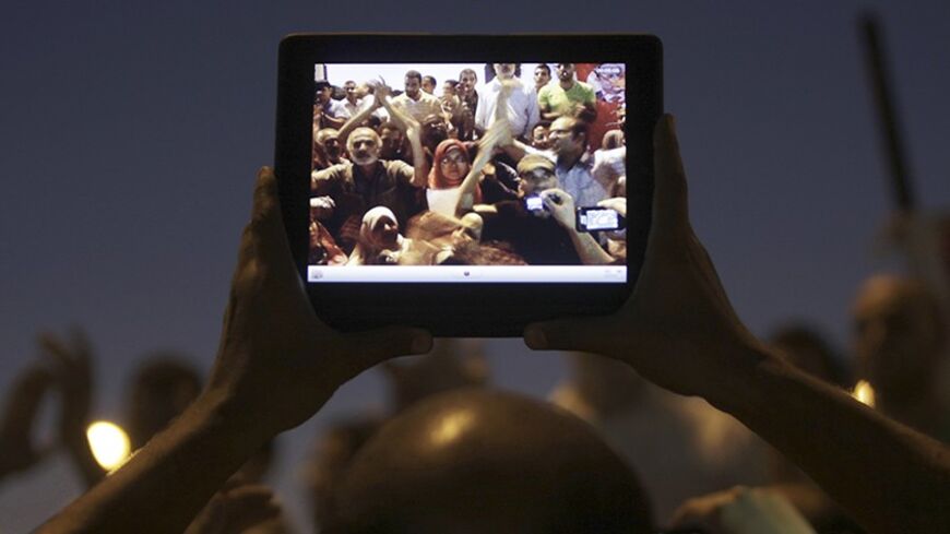 Egyptian protesters are pictured on a tablet device during a protest against general prosecutor Abdel Maguid Mahmoud and the Mubarak regime at Tahrir Square, the focal point of the Egyptian uprising, in Cairo October 11, 2012. Egypt's president removed the general prosecutor from his post on Thursday, appeasing demonstrators who accused him of presenting weak evidence in a case against Mubarak-era officials accused of planning attacks on protesters last year. REUTERS/Amr Abdallah Dalsh  (EGYPT - Tags: POLIT