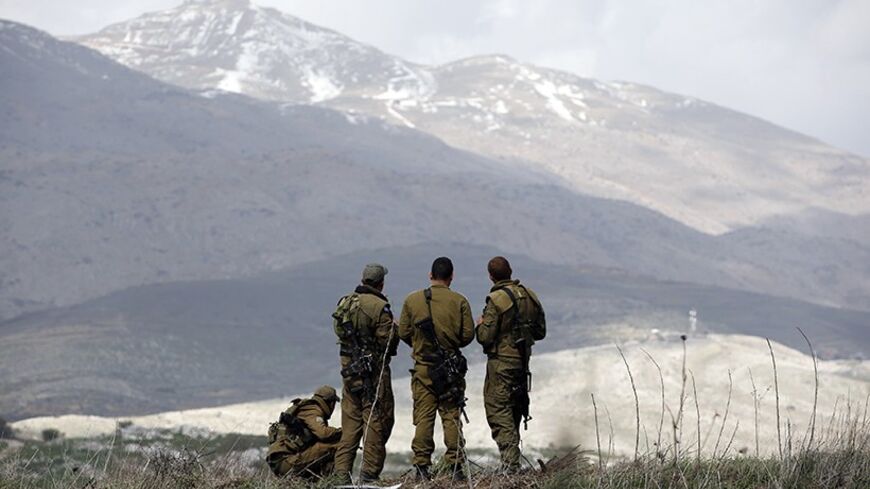 Israeli soldiers stand on a field overlooking Syria in the Golan Heights March 19, 2014. Israel launched air strikes on Wednesday against Syrian military sites in response to a roadside bombing that wounded four of its soldiers, but both sides signalled they were not seeking further escalation. REUTERS/Ronen Zvulun (CIVIL UNREST MILITARY POLITICS) - RTR3HQDT