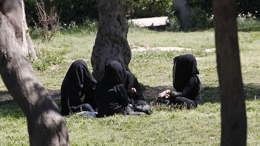 Veiled women sit as they chat in a garden in the northern province of Raqqa March 31, 2014. The Islamic State in Iraq and the Levant (ISIL) has imposed sweeping restrictions on personal freedoms in the northern province of Raqqa. Among the restrictions, Women must wear the niqab, or full face veil, in public or face unspecified punishments "in accordance with sharia", or Islamic law. REUTERS/Stringer   (SYRIA - Tags: POLITICS CIVIL UNREST CONFLICT RELIGION SOCIETY) - RTR3JCO4
