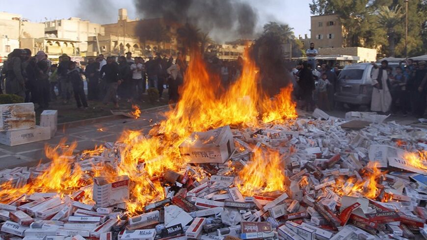 Fighters from Islamic State in Iraq and the Levant (ISIL) burn confiscated cigarettes in the city of Raqqa April 2, 2014. REUTERS/Stringer (SYRIA - Tags: POLITICS CIVIL UNREST CONFLICT RELIGION SOCIETY TPX IMAGES OF THE DAY) - RTR3JP4Z