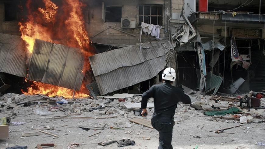 A civil defence worker runs towards a fire after what activists said was an air strike by forces loyal to Syrian President Bashar Al-Assad in Aleppo's Bustan al-Qasr April 18, 2014. REUTERS/Stringer (SYRIA - Tags: CONFLICT CIVIL UNREST) - RTR3LTHO