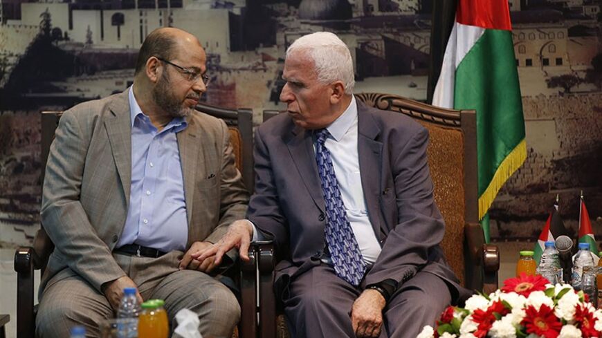 Senior Hamas leader Moussa Abu Marzouk (L) and Azzam Al-Ahmed, a senior Fatah official talk during their meeting in Gaza City April 22, 2014. The Palestine Liberation Organization (PLO) sent a delegation to Gaza on Tuesday to negotiate unity with militant group Hamas for the first time since their 2007 conflict, potentially boosting Fatah leader and Palestinian president Mahmoud Abbas's position. REUTERS/Mohammed Salem (GAZA - Tags: POLITICS) - RTR3M9J9
