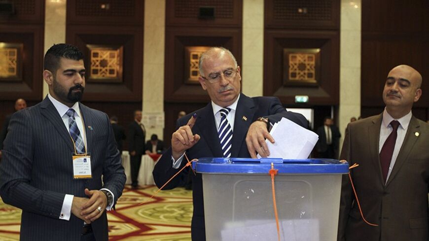 Osama al-Nujaifi (C), speaker of the Iraqi Council of Representatives, holds up his ink-stained finger as he casts his vote at a polling station during a parliamentary election in Baghdad April 30, 2014. Iraqis headed to the polls on Wednesday in their first national election since U.S. forces withdrew from Iraq in 2011, with Prime Minister Nuri al-Maliki seeking a third term amid rising violence. REUTERS/Mahmoud Raouf Mahmoud (IRAQ - Tags: ELECTIONS POLITICS) - RTR3N8ZF