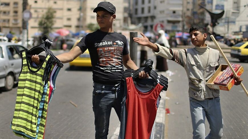 Palestinian boys sell cigarettes and clothes on a street in Gaza City May 1, 2014.  REUTERS/Mohammed Salem (GAZA - Tags: BUSINESS EMPLOYMENT SOCIETY) - RTR3NDLH