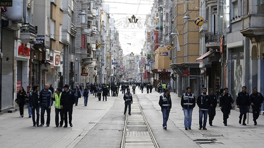 Plain clothes police walk on the main pedestrian street of Istiklal in central Istanbul during a May Day demonstration in Istanbul May 1, 2014. Turkish police fired tear gas, water cannon and rubber pellets on Thursday to try to stop thousands of people, some armed with fire bombs and fireworks, from defying a ban on May Day rallies and reaching Istanbul's central Taksim square.   REUTERS/Umit Bektas (TURKEY  - Tags: POLITICS CIVIL UNREST)   - RTR3NEGD