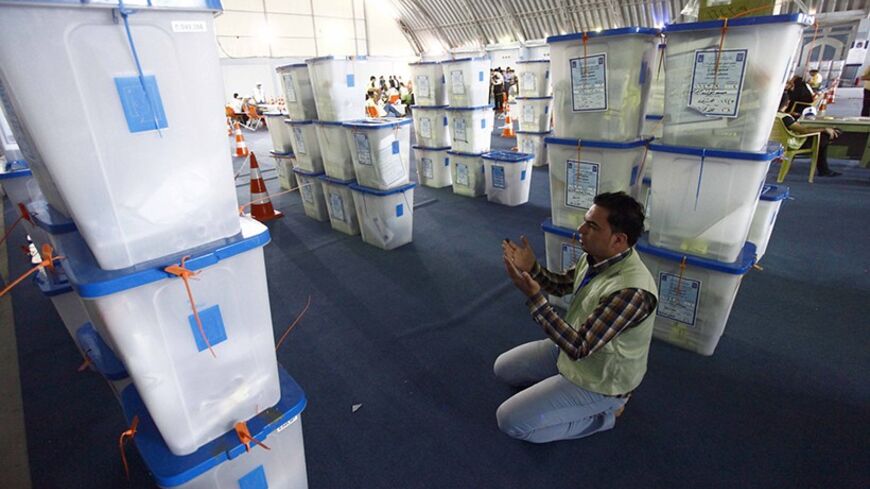 A member of the Independent High Electoral Commission prays near ballot boxes during a vote counting at an analysis centre in Najaf, 160 km (100 miles) south of Baghdad, May 2, 2014. Iraq held a democratic vote to choose a leader with no foreign troops present for the first time on Wednesday, as Shi'ite Prime Minister Nuri al-Maliki sought to hold power for a third term in a country again consumed by sectarian bloodshed. The electoral commission said 60 percent of all voters had so far cast a ballot, accord