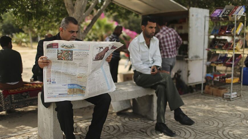 A Palestinian man reads a copy of Al-Quds newspaper in Gaza City May 7, 2014. The Hamas-run government in the Gaza Strip relaxed on Wednesday a ban on distribution of Palestinian newspapers published outside the enclave, calling it a step toward implementing a unity deal with the rival Fatah group. The return of Al-Quds, the biggest-selling Palestinian daily in the occupied West Bank where President Mahmoud Abbas's Fatah holds sway, was greeted enthusiastically by Gaza residents, who snapped up copies from 
