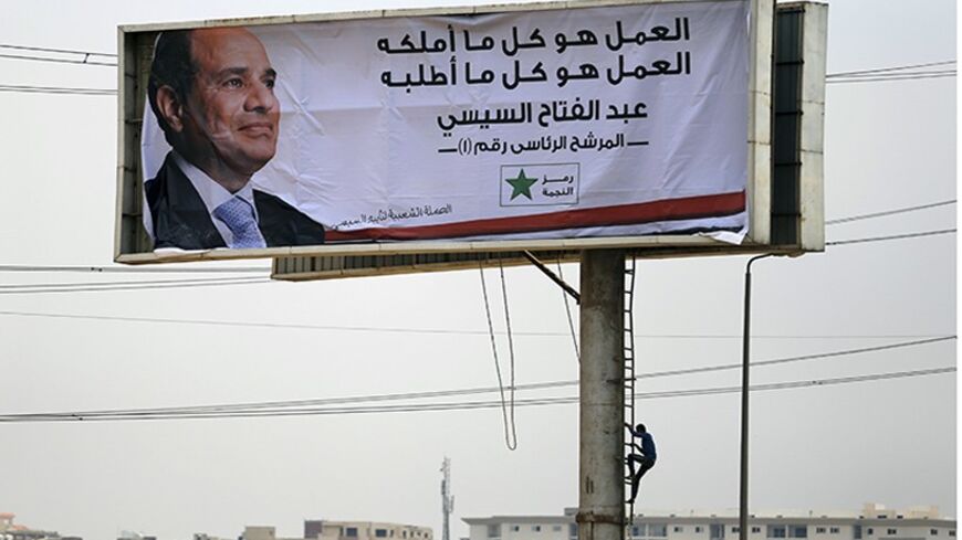 A worker climbs down after completing work on a campaign billboard of presidential candidate and Egypt's former army chief Abdel Fattah al-Sisi, along a highway in Cairo May 12, 2014. An influential Qatar-based Islamist whose fiery sermons have caused tension between Gulf states said on Sunday that Egyptian presidential front runner Abdel Fattah al-Sisi will only bring downfall to the country. Sisi is expected to easily win the May 26-27 presidential election. The only other candidate is leftist politician 