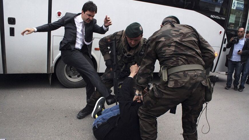 A protester is kicked by Yusuf Yerkel (L), advisor to Turkey's Prime Minister Tayyip Erdogan, as Special Forces police officers detain him during a protest against Erdogan's visit to Soma, a district in Turkey's western province of Manisa May 14, 2014. Four Turkish labour unions called for a national one-day strike on Thursday in protest against the country's worst industrial disaster that killed at least 282 people in a coal mine in western Turkey. Picture taken May 14, 2014. REUTERS/Mehmet Emin Al/Depo Ph