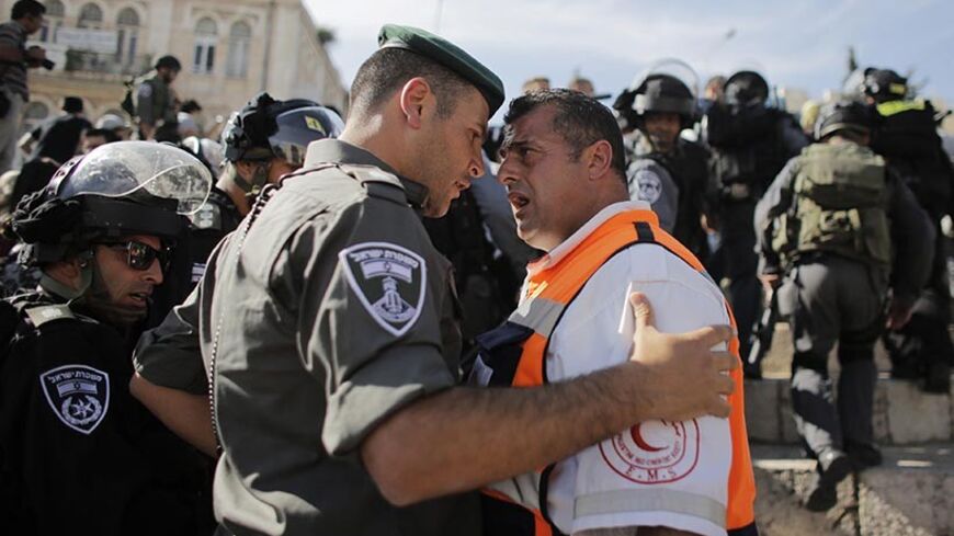 A Palestinian medic argues with an Israeli border policeman during a demonstration marking the 66th anniversary of the "Nakba," meaning catastrophe, when many Palestinians fled or were expelled from their towns and villages during the war of Israel's foundation in 1948, at Damascus Gate in Jerusalem's Old City May 15, 2014. An Israeli police spokesman said on Thursday that 5 Palestinian protesters were detained during the unauthorized demonstration in Jerusalem's Old City, where stones were thrown at police