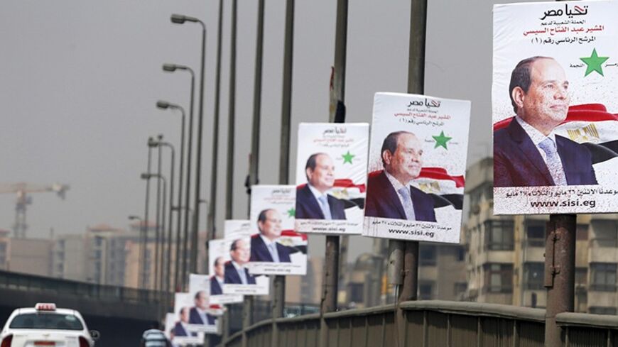A car travels past posters of presidential candidate and Egypt's former army chief and Abdel Fattah al-Sisi on a bridge in Cairo May 22, 2014. A presidential election will take place on May 26-27, which al-Sisi is expected to win.  REUTERS/Amr Abdallah Dalsh (EGYPT - Tags: POLITICS ELECTIONS TRANSPORT) - RTR3QDF4
