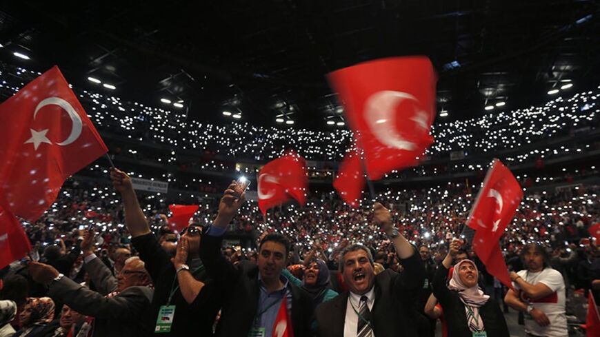 Supporters of Turkish Prime Minister Tayyip Erdogan hold up their mobile phones and wave Turkish flags ahead of his visit in Lanxess Arena in Cologne May 24, 2014. A visit by Erdogan to Cologne on Saturday to address thousands of expatriate Turks threatens to bring Turkey's political tensions to German streets, despite an appeal by Chancellor Angela Merkel for him to adopt a sensitive tone.        REUTERS/Wolfgang Rattay (GERMANY  - Tags: POLITICS CIVIL UNREST TPX IMAGES OF THE DAY)   - RTR3QNKQ