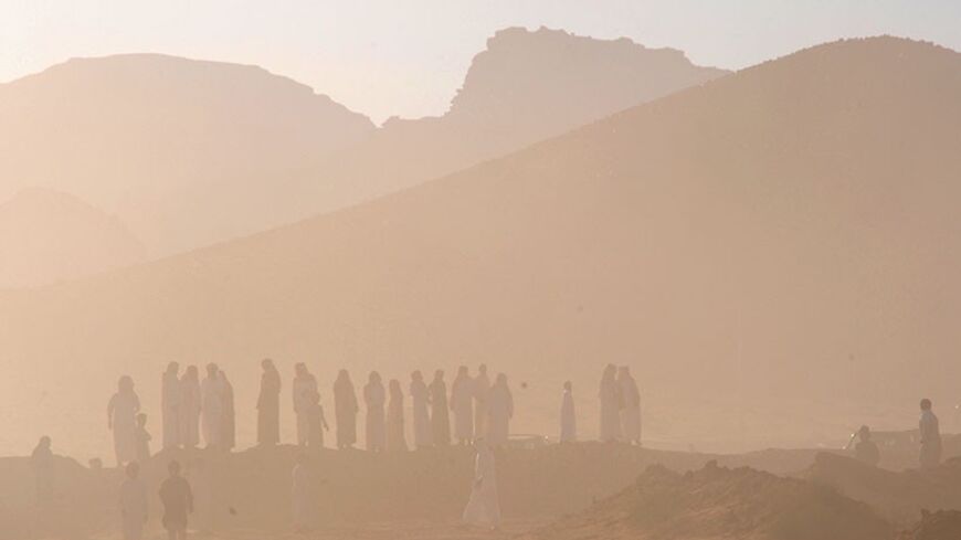 Heavy dust is seen as people wait for contestants during a camel race, an annual event organised for desert dwellers, in the desert of Aleghan, north of Saudi Arabia, in Tabuk June 18, 2013. REUTERS/Mohamed Al Hwaity (SAUDI ARABIA - Tags: SOCIETY TPX IMAGES OF THE DAY) - RTX10RVW