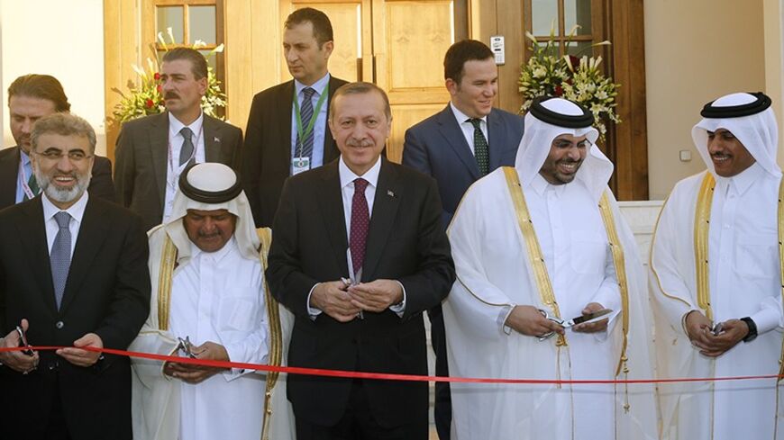 Turkey's Prime Minister Tayyip Erdogan (C) cuts the ribbon during the opening ceremony of the new building of the Turkish Embassy in Doha December 4, 2013. REUTERS/Mohammed Dabbous (QATAR - Tags: POLITICS) - RTX163FZ