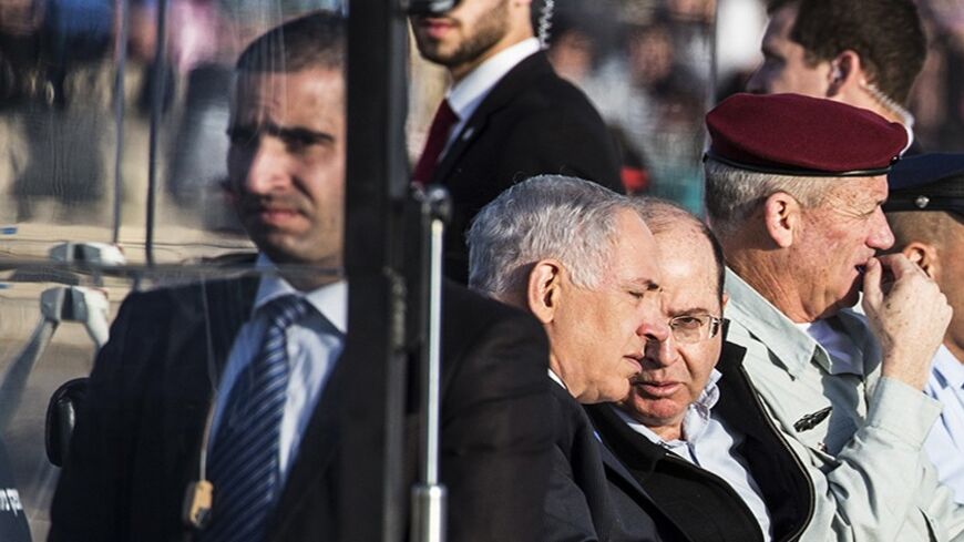 Israeli Prime Minister Benjamin Netanyahu (C) listens to Defence Minister Moshe Ya'alon (2nd R) as Chief of the General Staff Lieutenant General Benny Gantz (R) sits beside them during an air force pilots' graduation ceremony at Hatzerim air base in southern Israel December 26, 2013. REUTERS/Nir Elias (ISRAEL - Tags: MILITARY POLITICS) - RTX16UH7