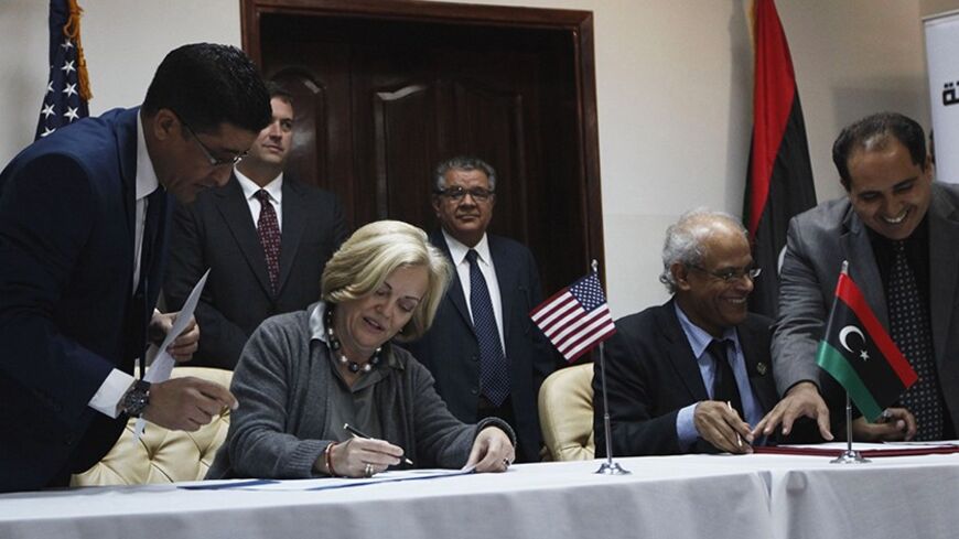 Libyan Justice Minister Salah Marghany (R), U.S. ambassador to Libya Deborah Jones (2nd L) during a signing ceremony of an agreement at the headquarters of the Ministry of Justice Tripoli Libya December 2, 2013. With Libya's army still in the making, Western powers are keen to halt chaos in the key European oil supplier and stop illicit arms spilling across North Africa. Picture taken December 2, 2013.  REUTERS/Ismail Zitouny (LIBYA - Tags: POLITICS CIVIL UNREST) - RTX16VPU