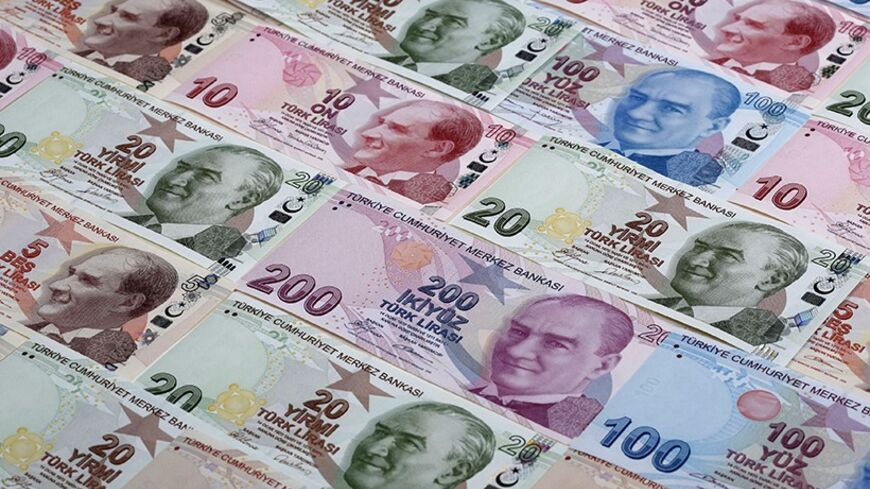 Turkish lira banknotes are seen in this photo illustration taken in Istanbul January 7, 2014. Turkey's lira slipped against the U.S. dollar on Wednesday as the government bond yield curve, which had briefly inverted on Tuesday because of speculation about an emergency rate hike to rescue the currency, returned to a positive slope. Picture taken January 7, 2014. REUTERS/Murad Sezer (TURKEY - Tags: BUSINESS) - RTX1761J