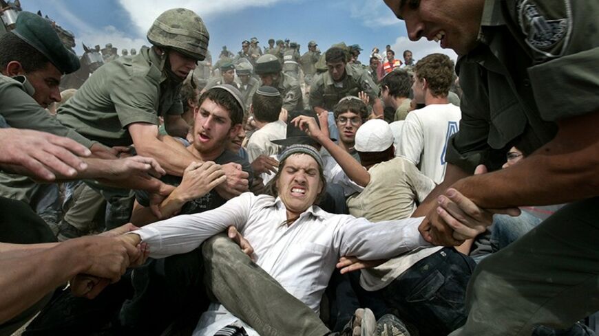 Jewish settlers scuffle with Israeli border police attempting to remove the Jewish outpost of Mitzpeh Yitzhar in the West Bank May 17, 2004. Israeli troops clashed on Monday with hundreds of Jewish settlers trying to prevent the dismantling of an unauthorised settlement outpost in the West Bank. - RTXMM3O
