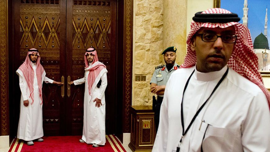 Aides stand outside the room where US President Barack Obama meets with Saudi King Abdullah, at Rawdat Khurayim, the Saudi King Abdullah's desert camp 60 KM (35 miles) northeast of Riyadh, during his meeting with US President Barack Obama on March 28, 2014. Obama arrived in Riyadh for talks with Saudi King Abdullah as mistrust fuelled by differences over Iran and Syria overshadows a decades-long alliance between their countries. AFP PHOTO / SAUL LOEB        (Photo credit should read SAUL LOEB/AFP/Getty Imag