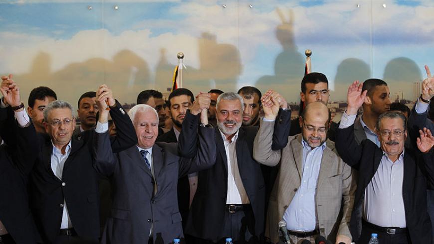 (From L to R) Palestinian legislator Mustafa Barghouti, Palestinian Fatah delegation chief Azzam al-Ahmed, Hamas prime minister in the Gaza Strip Ismail Haniya, Hamas deputy leader Musa Abu Marzuk, and secretary-general of the Palestinian Arab Front (PAF) Jameel Shehadeh, pose for a picture in Gaza on April 23, 2014. Rival Palestinian leaders from the West Bank and Gaza Strip agreed to form a unity government within five weeks as peace talks with Israel face collapse. AFP PHOTO / SAID KHATIB        (Photo c