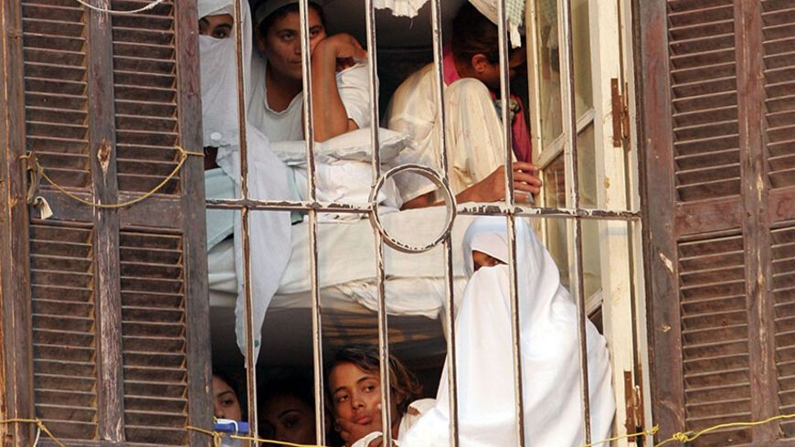 Women prisoners look out a barred window of Al-Qanater prison in Cairo October 6, 2007. Egypt's Interior Ministry invited representatives from the Egyptian Organization for Human Rights to visit the prison, after complaints of human rights violation were made by inmates in the prison. REUTERS/Nasser Nuri (EGYPT) - RTR1UNPQ