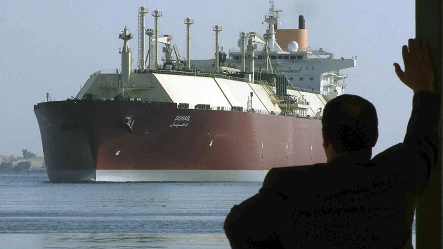 A man looks as the world's biggest Liquefied Natural Gas (LNG) tanker DUHAIL as she crosses through the Suez Canal April 1, 2008. The Qatari tanker, which was built to transfer LNG from Qatar to Europe and the U.S., is on her first trip ever from Qatar to Spain.    REUTERS/Stringer   (EGYPT) - RTR1YZYN
