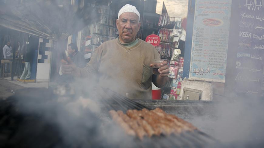 A man grills kebab, which is used to prepare sandwiches for passers-by, along a street corner in Cairo February 23, 2010. REUTERS/Asmaa Waguih(EGYPT - Tags: FOOD SOCIETY) - RTR2AROO