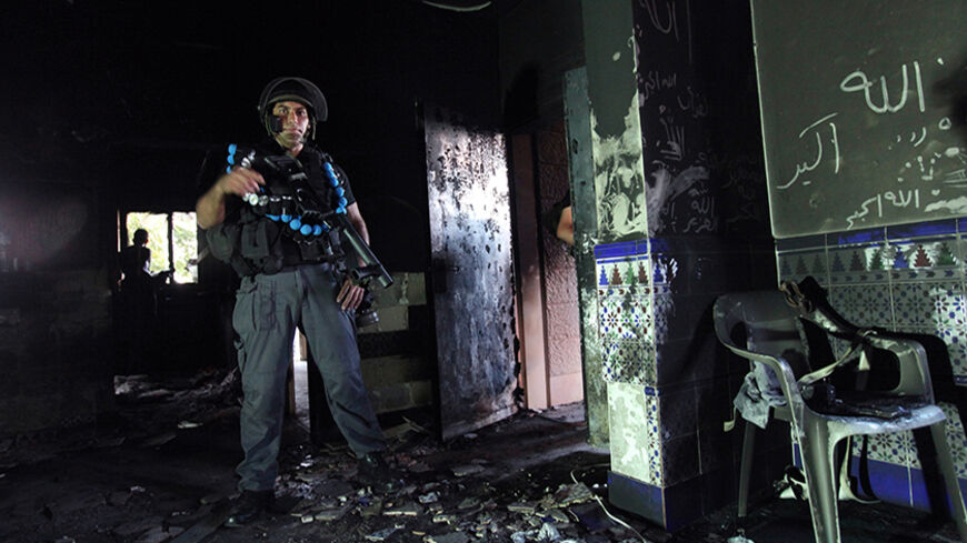 An Israeli police officer stands inside a burnt mosque in the Bedouin village of Tuba-Zangariya in northern Israel October 3, 2011, before the arrival of Israel's President Shimon Peres. They strike in the dead of night, setting fire to mosques and daubing their walls with "Price Tag" graffiti, the defiant slogan of Israeli settlers waging a vigilante campaign branded as "un-Jewish" by President Shimon Peres.   The "price-taggers" have vowed to avenge any move by Israeli authorities to uproot settlement out