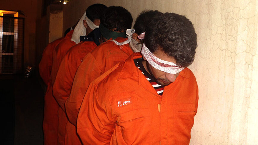 Blindfolded suspected militants, with possible links to al-Qaeda, are seen at Iraqi police headquarters in Diyala province, north of Baghdad December 5, 2011. Police forces arrested 30 suspected militants during a raid in Diyala province, a police source said.   REUTERS/Stringer (IRAQ - Tags: CONFLICT) - RTR2UVUD
