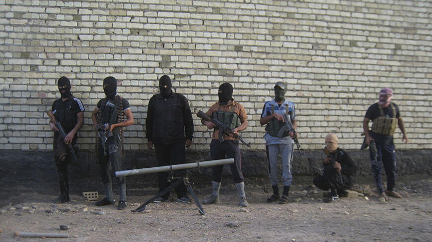Masked Sunni gunmen pose for a photo during a patrol outside the city of Falluja April 28, 2014. Iraqi soldiers say they have been trapped in and around the western city of Ramadi. They say they have run low on tank shells, lack aerial cover and armoured vehicles, and have been hit by high casualties and desertion rates. In March and April, ISIL seized a dam in Fallujah, flooded farmland on the outskirts of Baghdad in Abu Ghraib, and drained offshoots of the Euphrates river; the Iraqi government evacuated t