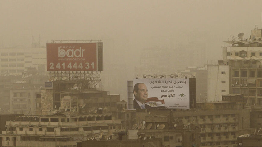 A billboard of president and former army chief Abdel Fattah al-Sisi is seen on top of a building as sandstorm hits the city of Cairo, June 4, 2014. Former army chief Abdel Fattah al-Sisi won 96.91 percent in Egypt's presidential vote last week, the election commission said on Tuesday, confirming interim results that had given him a landslide victory. REUTERS/Amr Abdallah Dalsh (EGYPT - Tags: POLITICS ENVIRONMENT SOCIETY) - RTR3S7JO